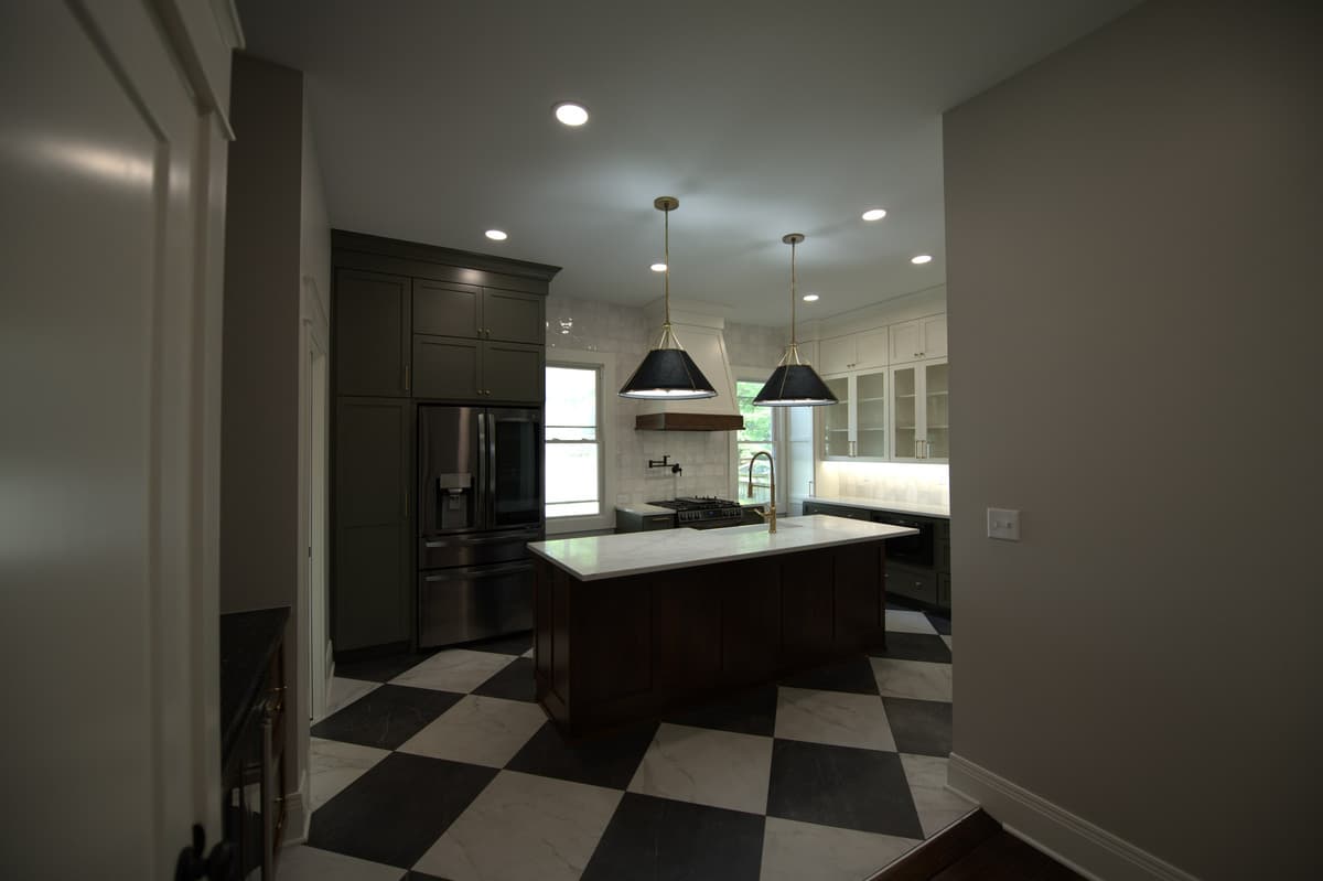 Kitchen with white upper cabinets, dark lower cabinets, checkered floor