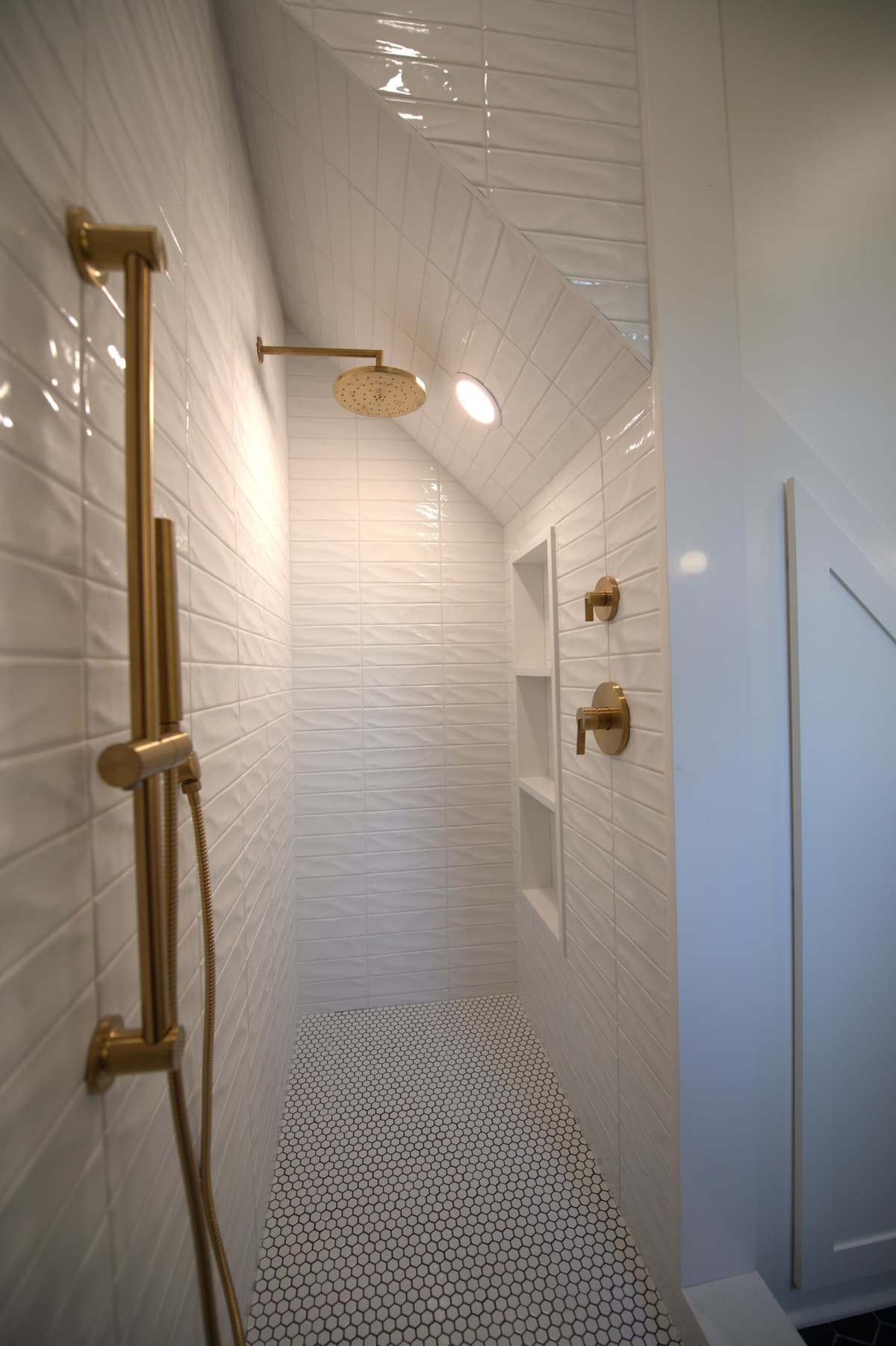 Shower close-up showing tile and brass shower head