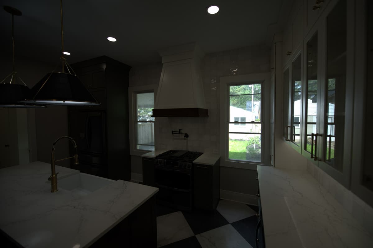 Kitchen looking toward windows, dark cabinetry