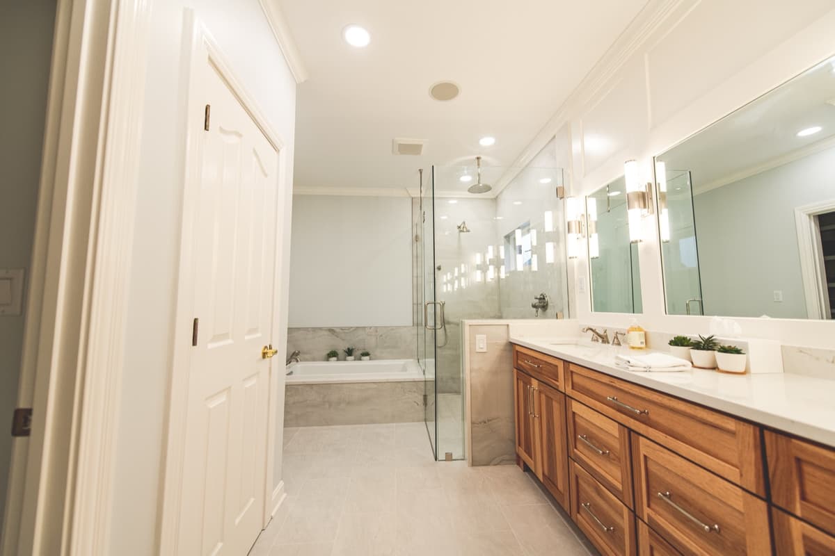 Walnut vanity with white quartz top, sconces between mirrors